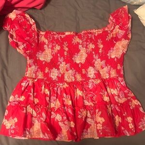 A red and flowered off the shoulder top. Form flattering and figure sculpting.